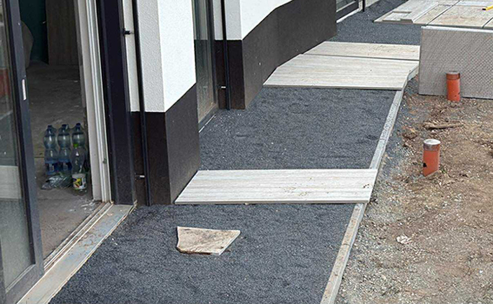 Colocación de bordillo y gravilla de asiento junto al edificio