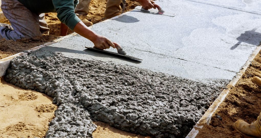 Fratasado de hormigón fresco en la construcción de una acera